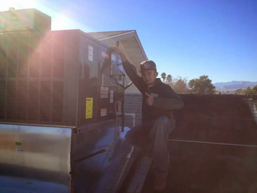 HVAC technician performing Air Duct Cleaning on a rooftop unit in Jackson